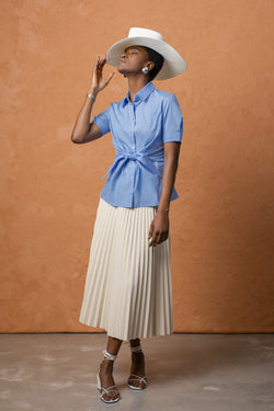 The shirt hits the top of the model's hip and fits true to size. It flares out a bit at the hemline.